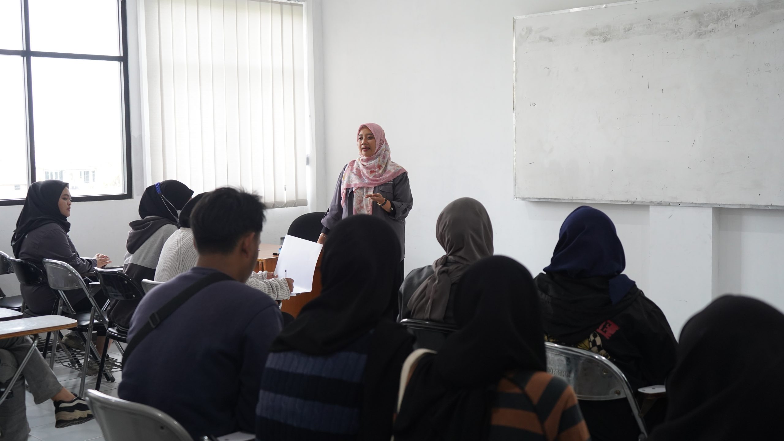 Mahasiswa sedang mendengarkan penjelasan terkait syarat Beasiswa RMP dan program bantuan pendidikan Pemkot Bandung di dalam kelas.